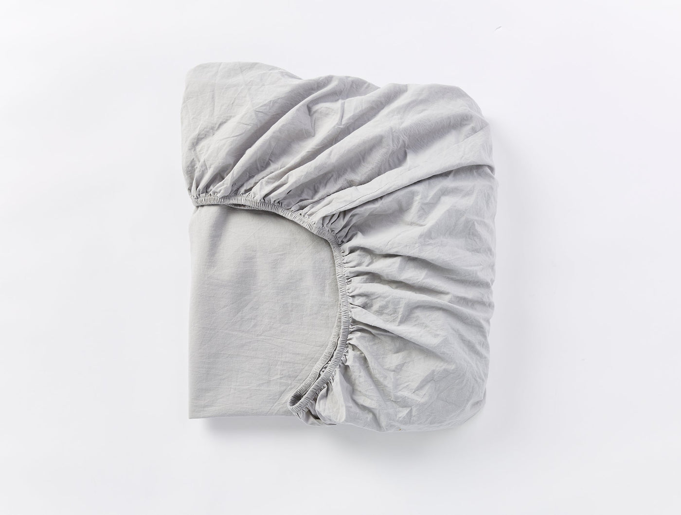 Folded silver grey fitted sheet showing elasticized corner detail.