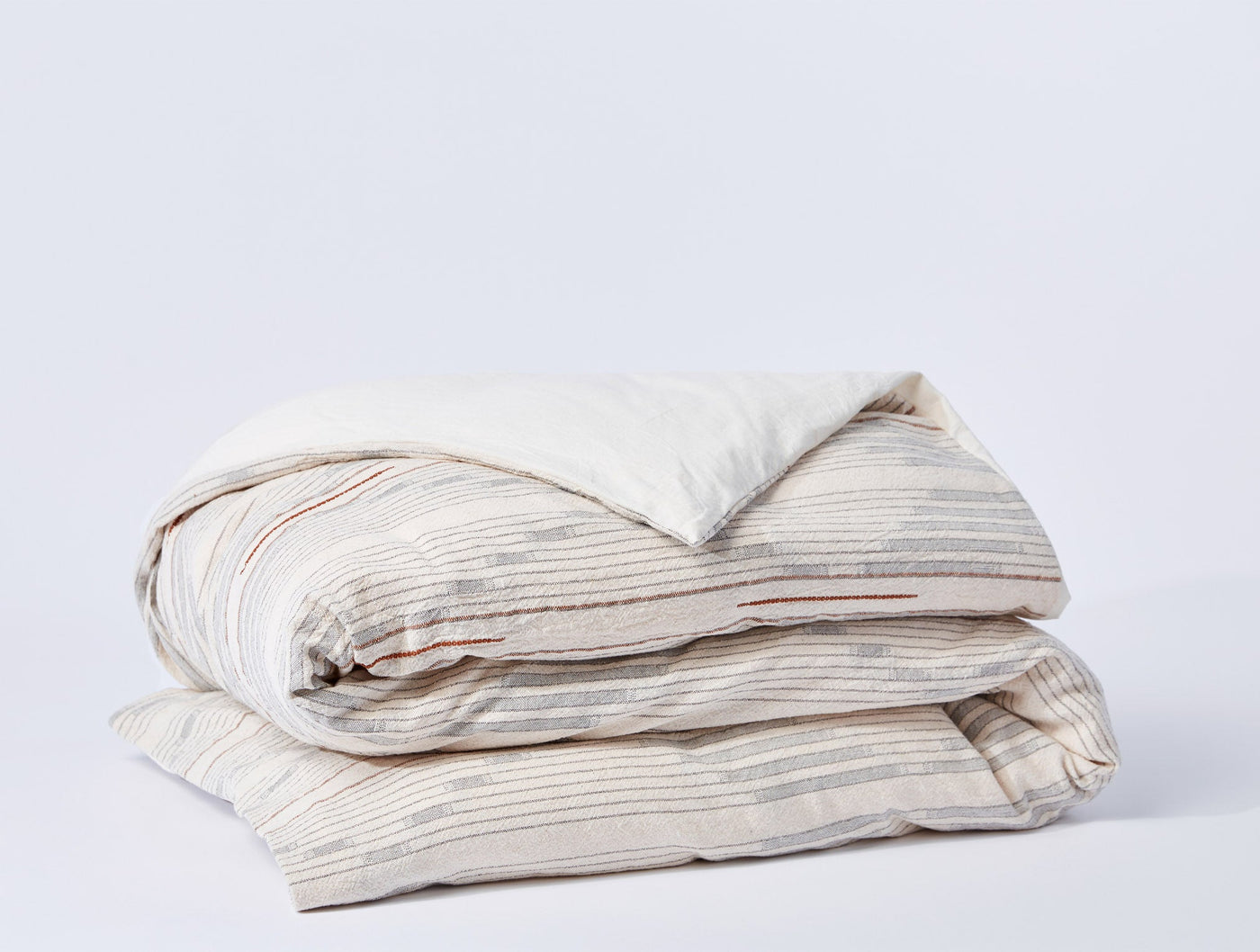 Coyuchi Morelia duvet cover in ivory with multicolor stripe, neatly folded.