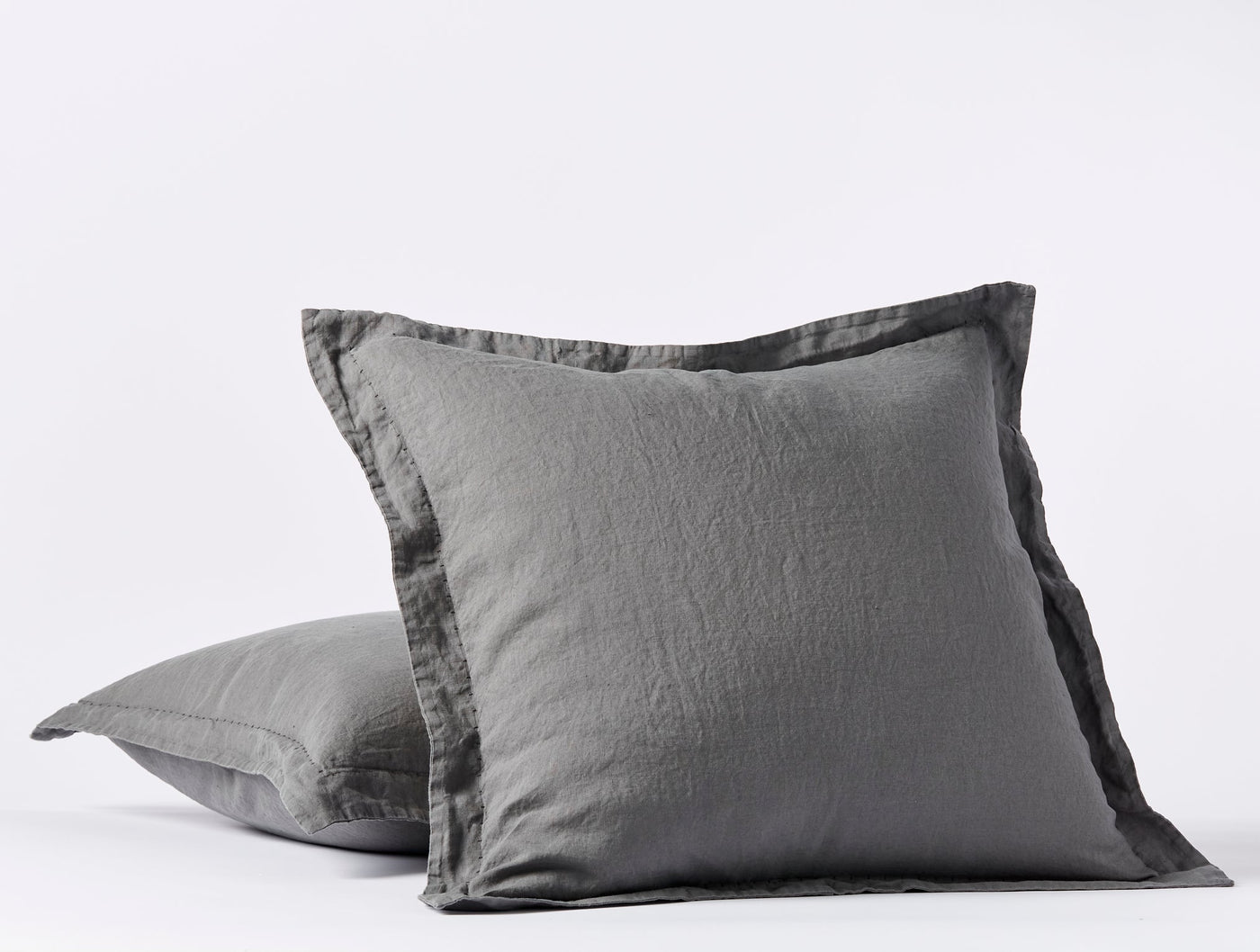 Close-up of Coyuchi Relaxed Linen sham pair in slate grey with flanged edge detail.