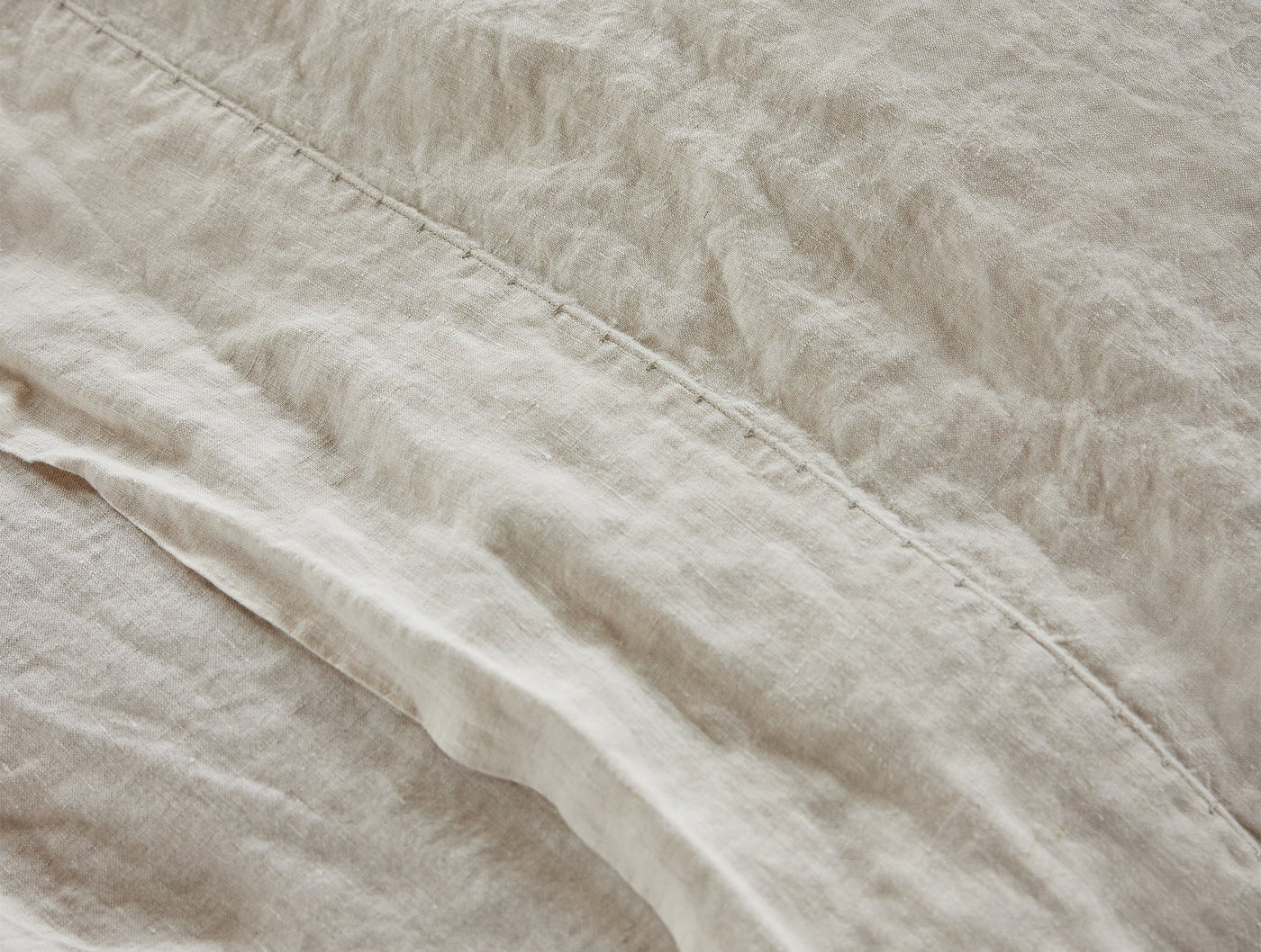 Close-up of natural linen weave texture and stitched hem on Coyuchi Relaxed Linen duvet cover.