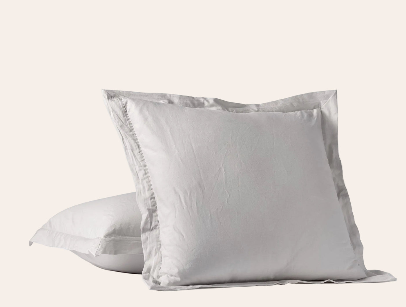 Dove grey sateen pillow shams stacked, showing wide flange border detail.