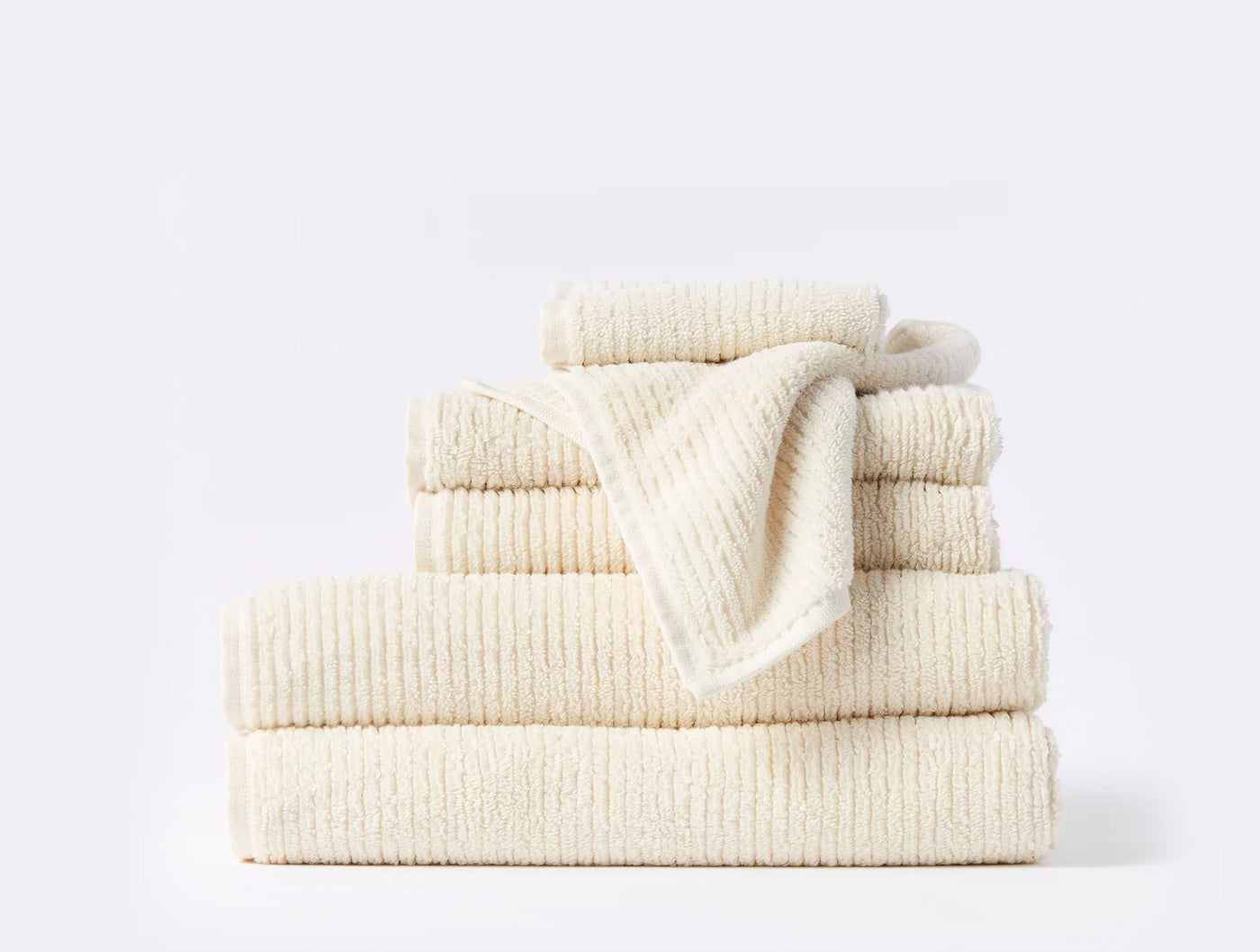 Close-up of Coyuchi Temescal Ribbed towel set in ivory, showing ribbed texture across stacked pieces.