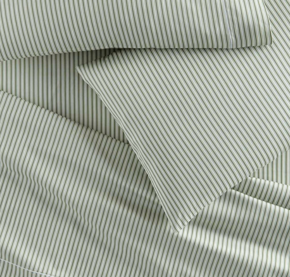 Close-up of green and white striped fabric with a subtle pattern.