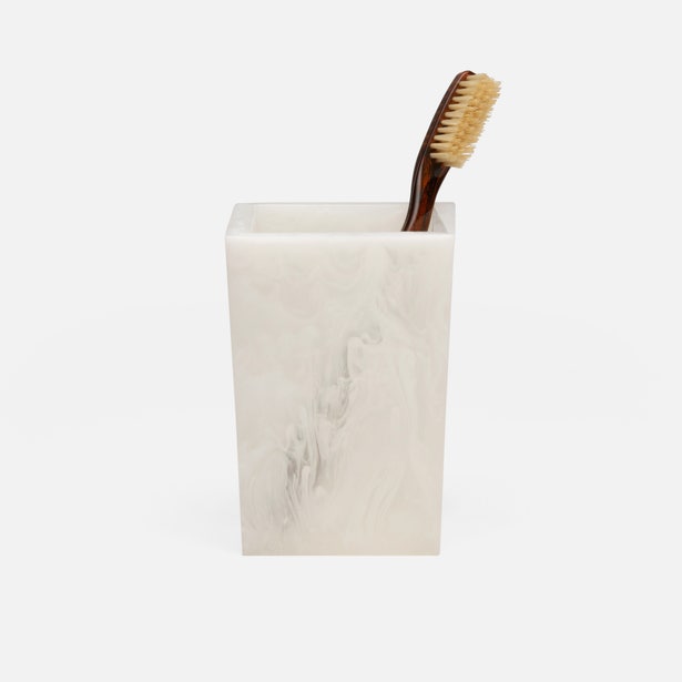 Abiko brush holder in ivory marbled resin with a toothbrush, angled front view.