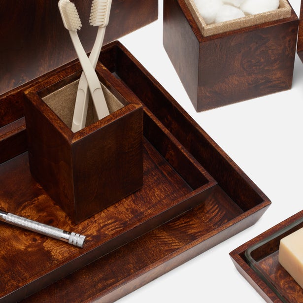 Dark burl wood bathroom accessories set with tray, toothbrush holder, and covered jar.