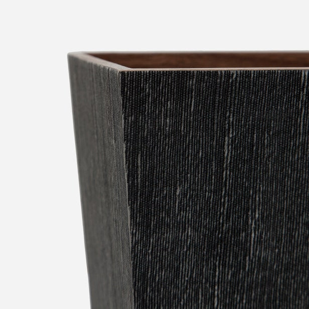 Close-up of Bruges wastebasket corner showing charcoal linear texture and warm interior contrast.
