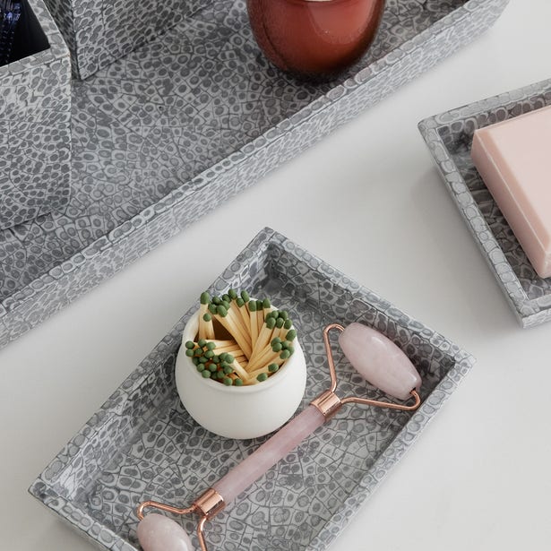 Grey snakeskin-embossed Callas tray styled with a rose quartz roller and match holder.