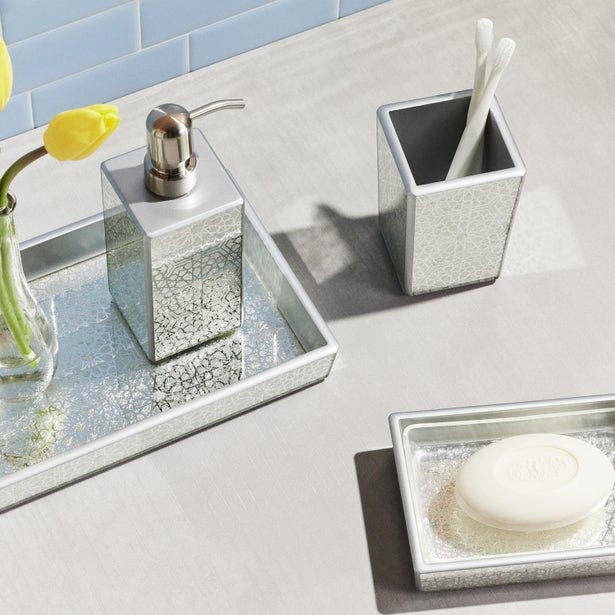 Crackled mirror bath set with tray, soap dispenser, cup, and dish styled on marble counter.