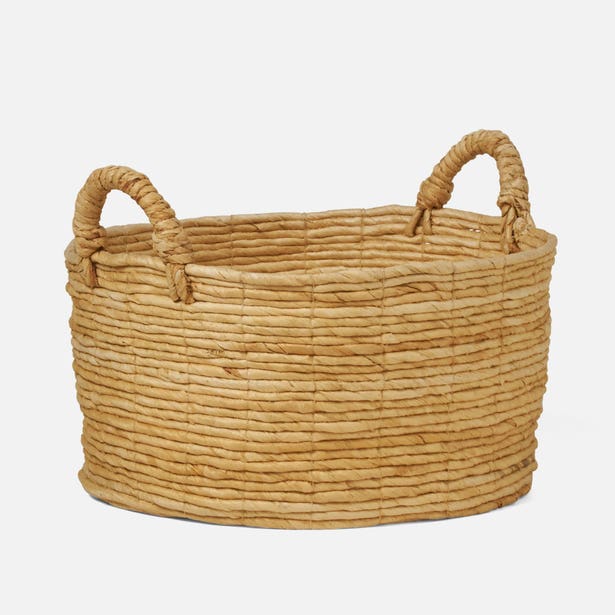 Natural woven water hyacinth basket with rope handles, angled front view.
