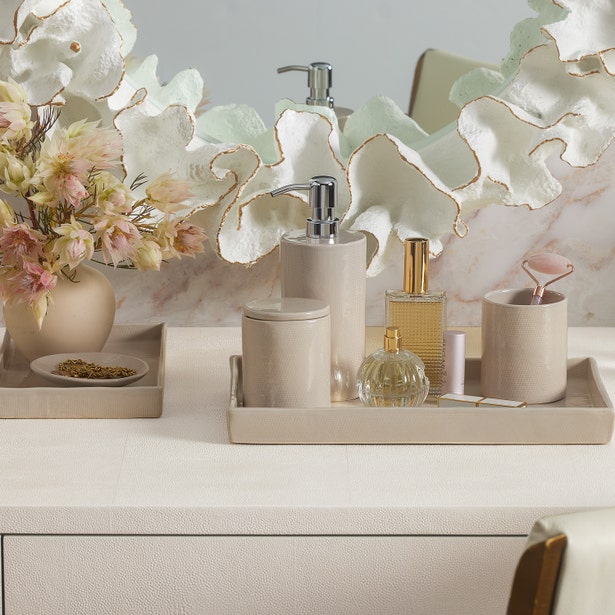 Cordoba bath canister styled on a vanity tray with soap dispenser and perfume bottle.