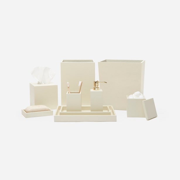 Ivory lacquered bathroom accessory set styled together, featuring soap pump with gold dispenser.