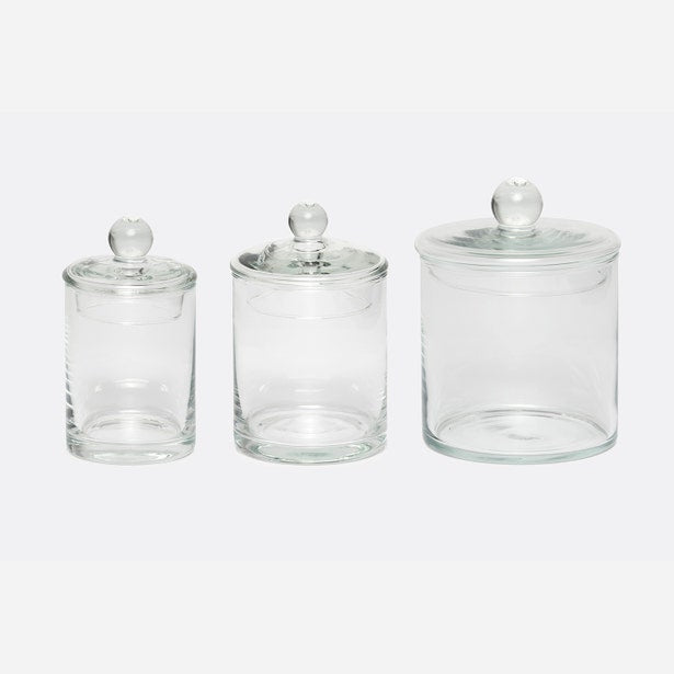 Three Pigeon & Poodle Darby clear glass bath canisters with knob lids, varying sizes.