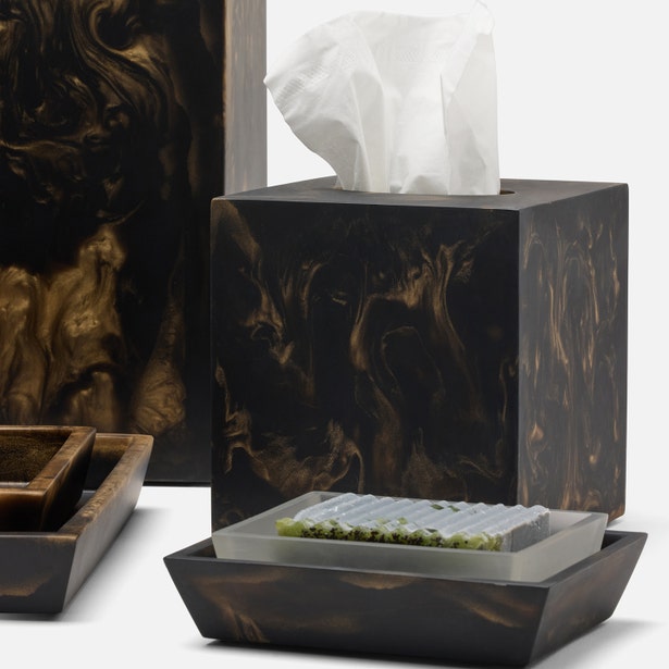 Dark tortoiseshell resin nesting tray set with frosted glass insert, styled with matching bath accessories.