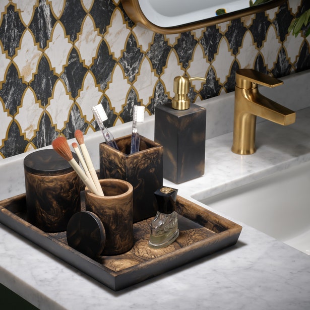 Dark tortoise-finish bath accessories set styled on marble vanity with Moorish tile backdrop.