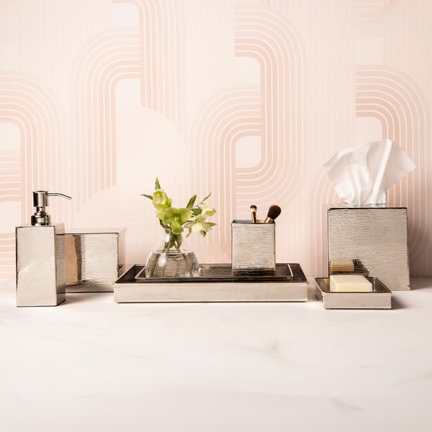 Elgin bathroom accessories set in silver, styled on marble with pink arch wallpaper.