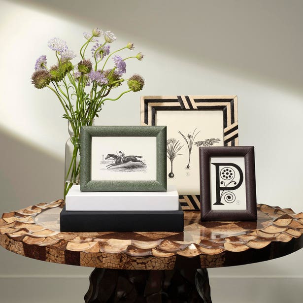 Three Oxford frames by Pigeon & Poodle styled on a wood table with florals.