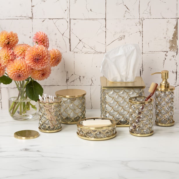 Gila collection displayed on marble vanity with tissue box, soap dish, and dispenser in gold scale motif.