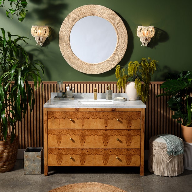 White ceramic soap pump on a marble vanity top in a green-walled bathroom vignette.