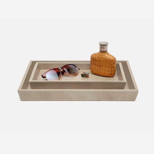 Pigeon & Poodle Hampton ivory faux leather nesting tray set styled with sunglasses and woven bottle.