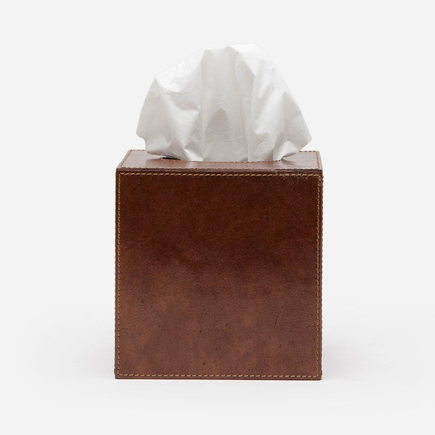 Square brown leather tissue box cover with contrast stitching, tissue emerging from top.