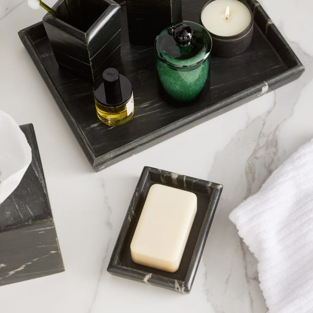 Black marble Pigeon & Poodle Kavala soap dish with ivory bar soap, styled on marble surface with towel.