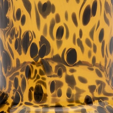Close-up of amber tortoiseshell glass carafe with dark brown spot pattern.