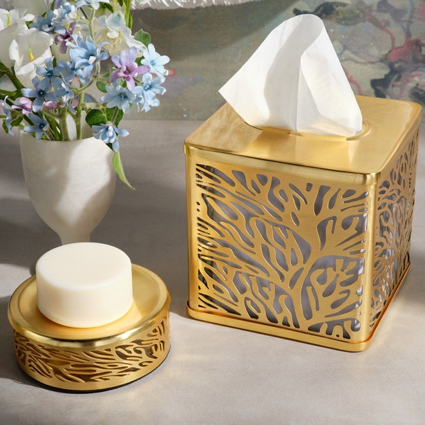 Gold cutwork tissue box cover and soap dish with floral motif, styled on marble surface.