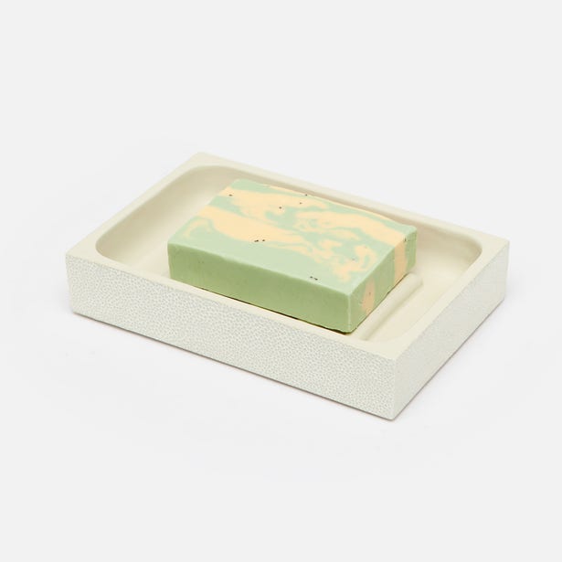Ivory shagreen-textured soap dish holding a green and peach marbled bar soap.