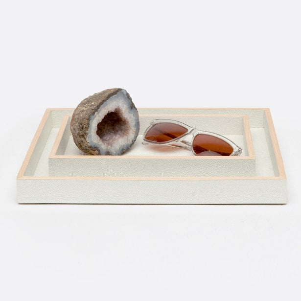 Two ivory Manchester nesting trays styled with a geode and sunglasses, rose gold trim detail.