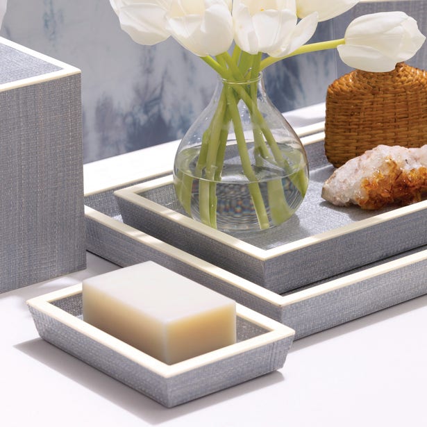 Grey linen-wrapped Maranello tray set styled with soap, white tulips, and crystals.