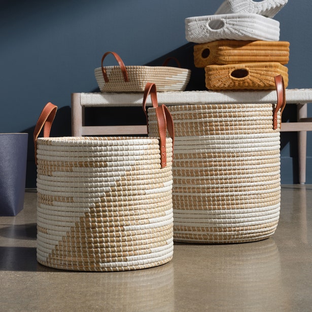 Two Pigeon & Poodle Olinda hampers in ivory and natural, tan leather handles, styled on floor.