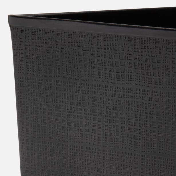 Close-up of Pigeon & Poodle Remy wastebasket corner in matte black with linen-embossed texture.