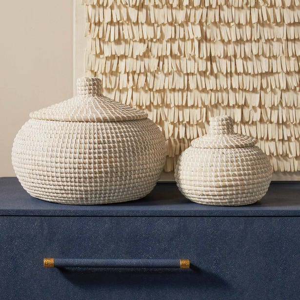 Pigeon & Poodle Roslyn ivory woven basket set, two lidded sizes on navy dresser.