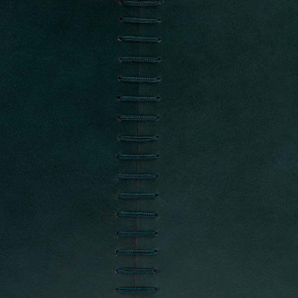 Close-up of teal fabric with vertical row of decorative whipstitch embroidery detailing.