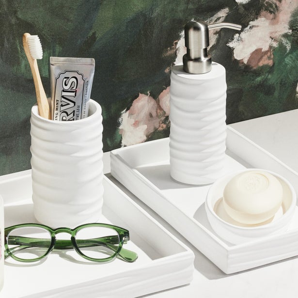Pigeon & Poodle Solin white bath accessories set styled with soap dish and pump dispenser.