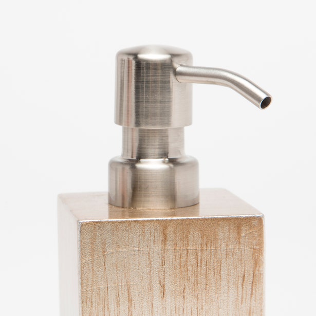 Close-up of Tanlay soap pump's brushed nickel dispenser head and textured champagne resin base.
