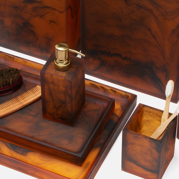 Close-up of Pigeon & Poodle Tavira amber tortoise resin bath accessories set styled on white surface.