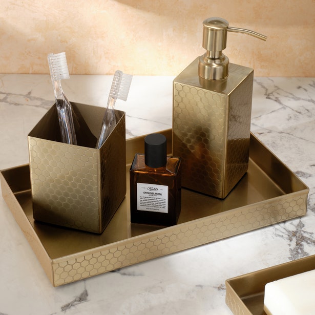 Temara brush holder in brass with honeycomb texture, styled on matching tray with soap dispenser.