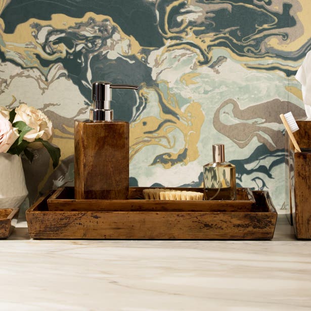 Reclaimed wood bathroom tray styled with soap dispenser and accessories against marble wall.