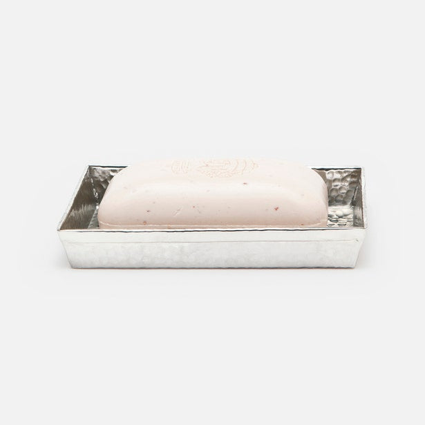 Hammered silver-tone Verum soap dish holding a blush bar of soap, angled view.