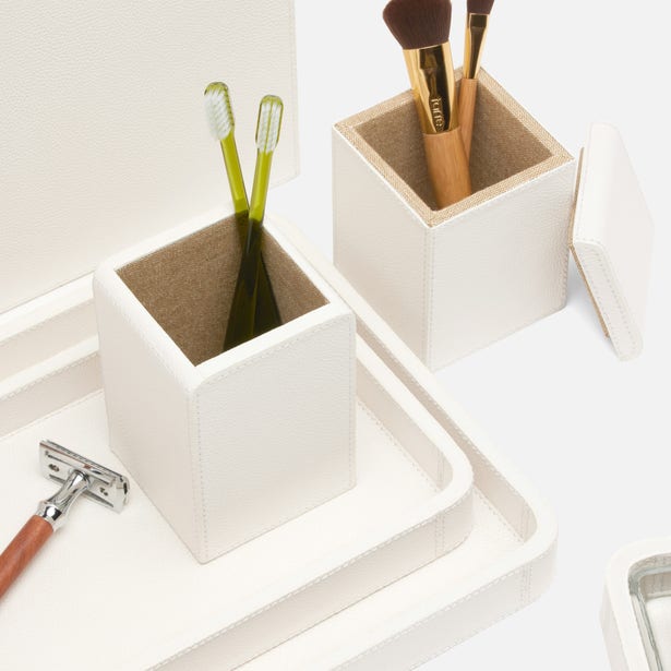 Two white leather Pigeon & Poodle Victoria canisters styled on a tray with brushes and toothbrushes.