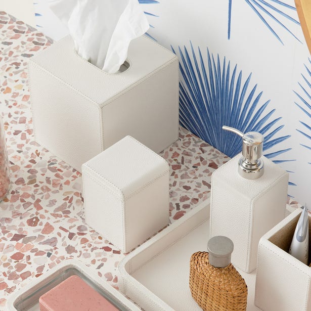 White leather-stitched soap pump styled with matching Victoria bathroom accessories on terrazzo surface.