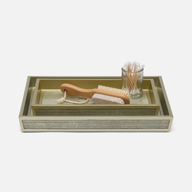 Stacked gold and silver textured Waterford bath trays styled with a brush and cotton swab glass.