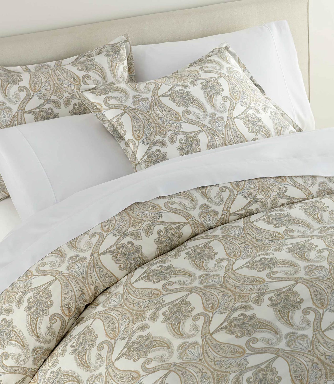 Taupe and ivory paisley pattern detail on Peacock Alley duvet cover styled with white shams.