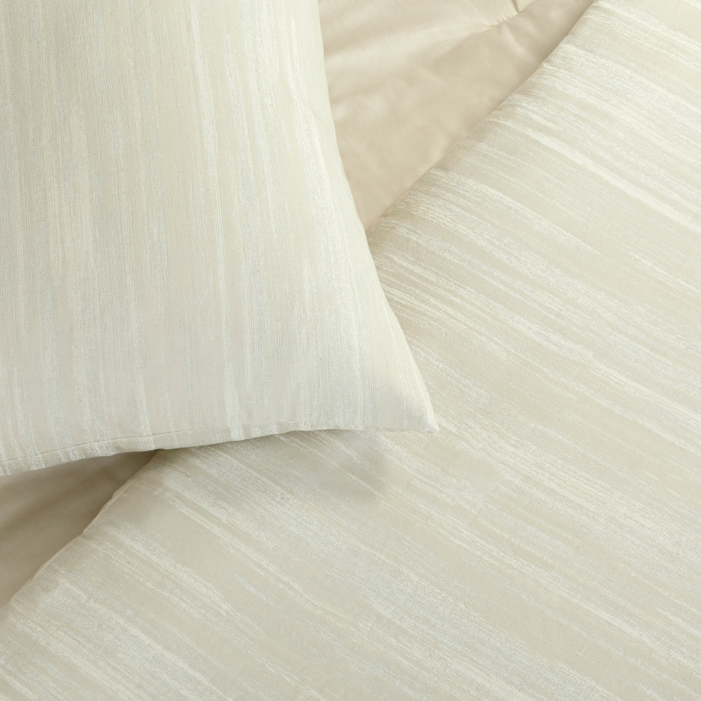 Close-up of ivory Ann Gish Palais comforter set showing subtle vertical stripe texture.