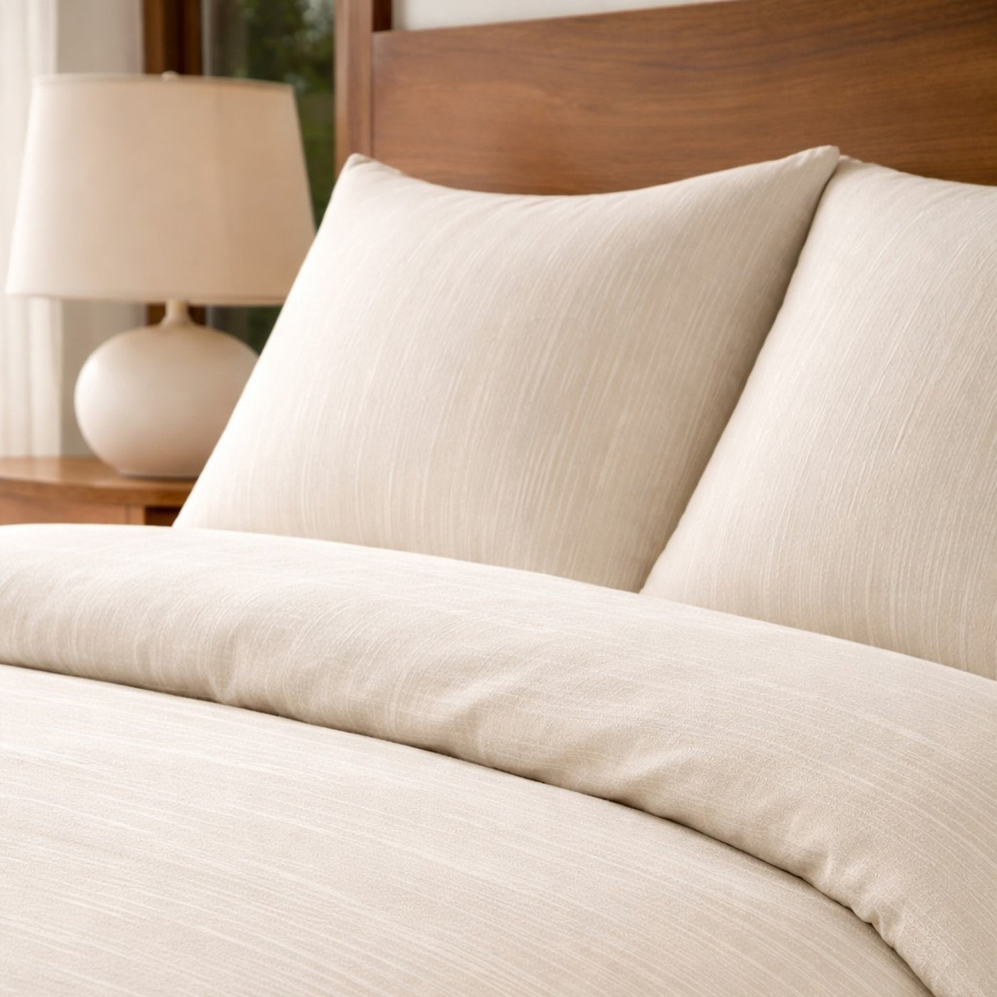 Close-up of Ann Gish Palais comforter set in ivory with subtle textured stripe weave.