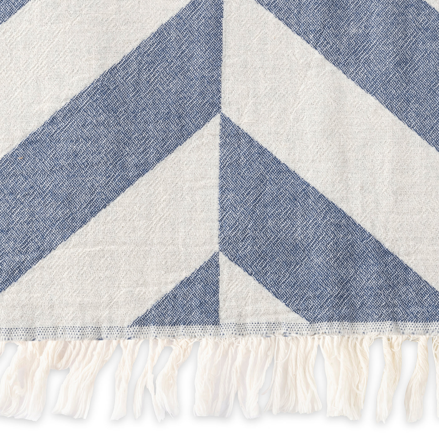 A close-up of the Matouk Paros | Beach Towel, featuring blue and white diagonal stripes and white fringe along the edge.