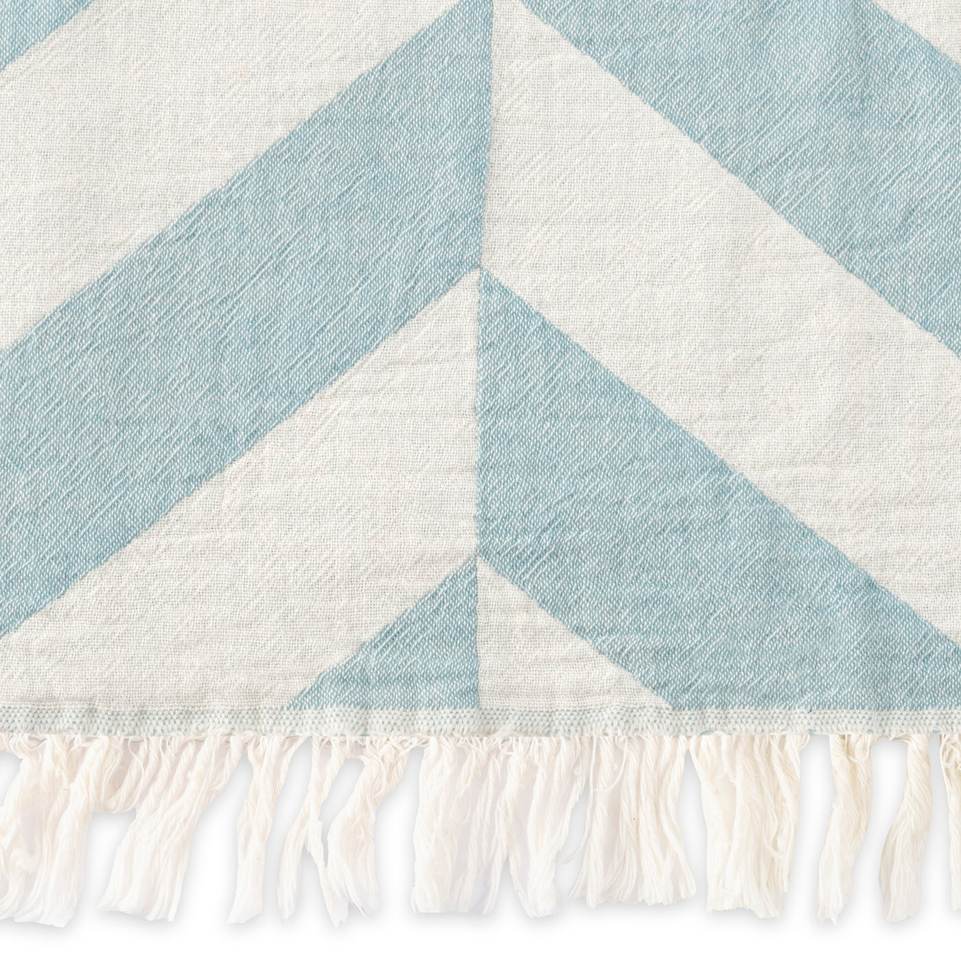 The Matouk Paros | Beach Towel showcases a blue and white chevron design with white fringe along the bottom edge.