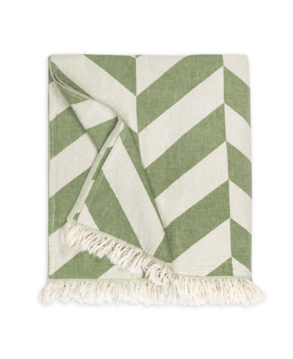 The Matouk Paros Beach Towel, featuring a green and white chevron pattern and fringed edges inspired by classic Fouta towels, is shown folded on a plain white background.
