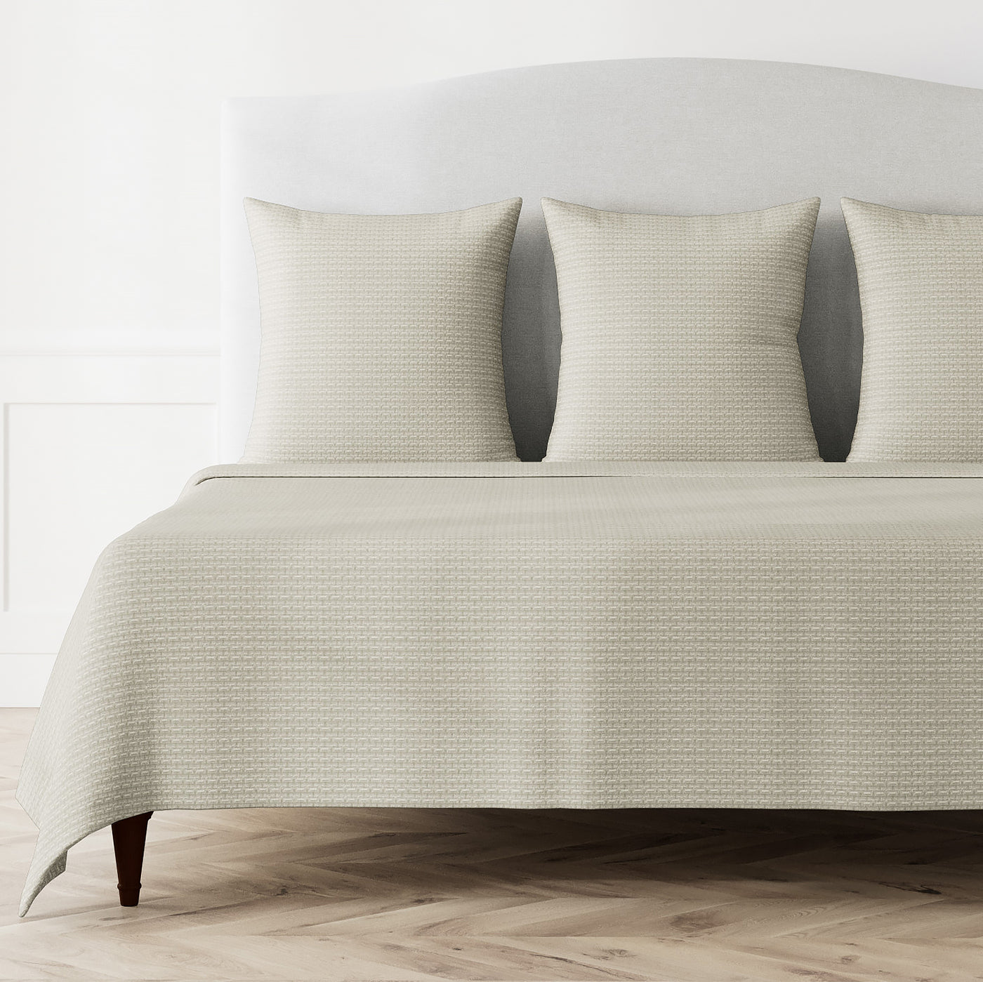 Ivory Ann Gish Pavilion coverlet with geometric woven texture on a styled bed with matching shams.